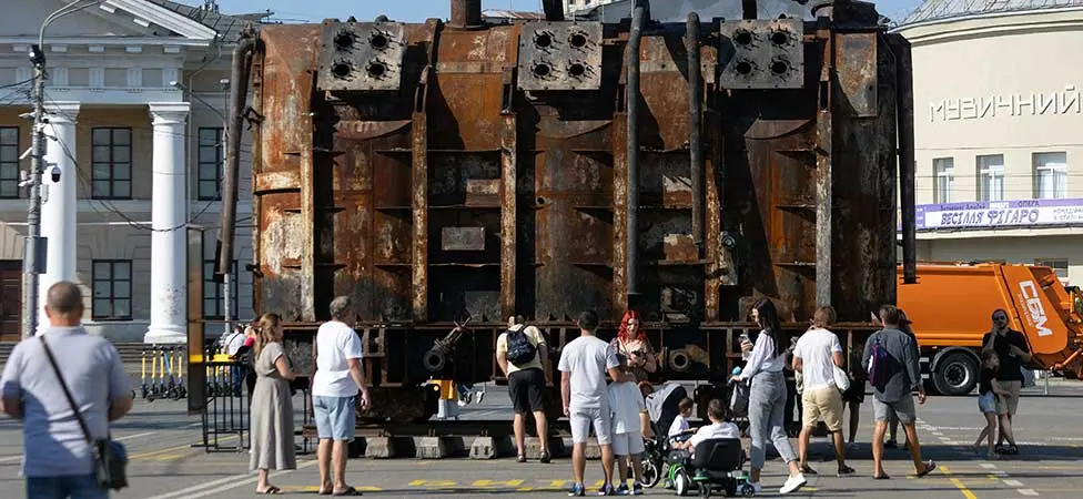 En stor utbränd transformator och människor framför den.