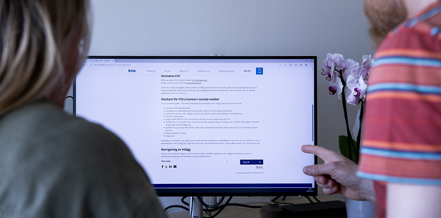 Kvinna och man pekar på datorskärm.