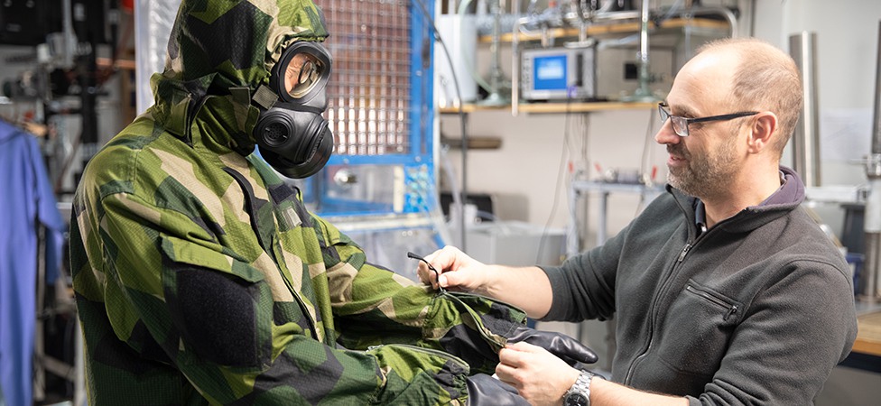 Person i skyddskläder och forskare