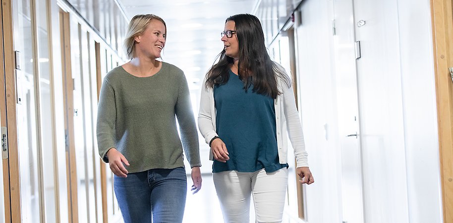 Två personer går i en korridor