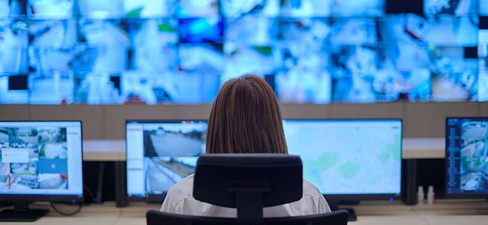 Tre medarbetare har ett möte framför dataskärmar 